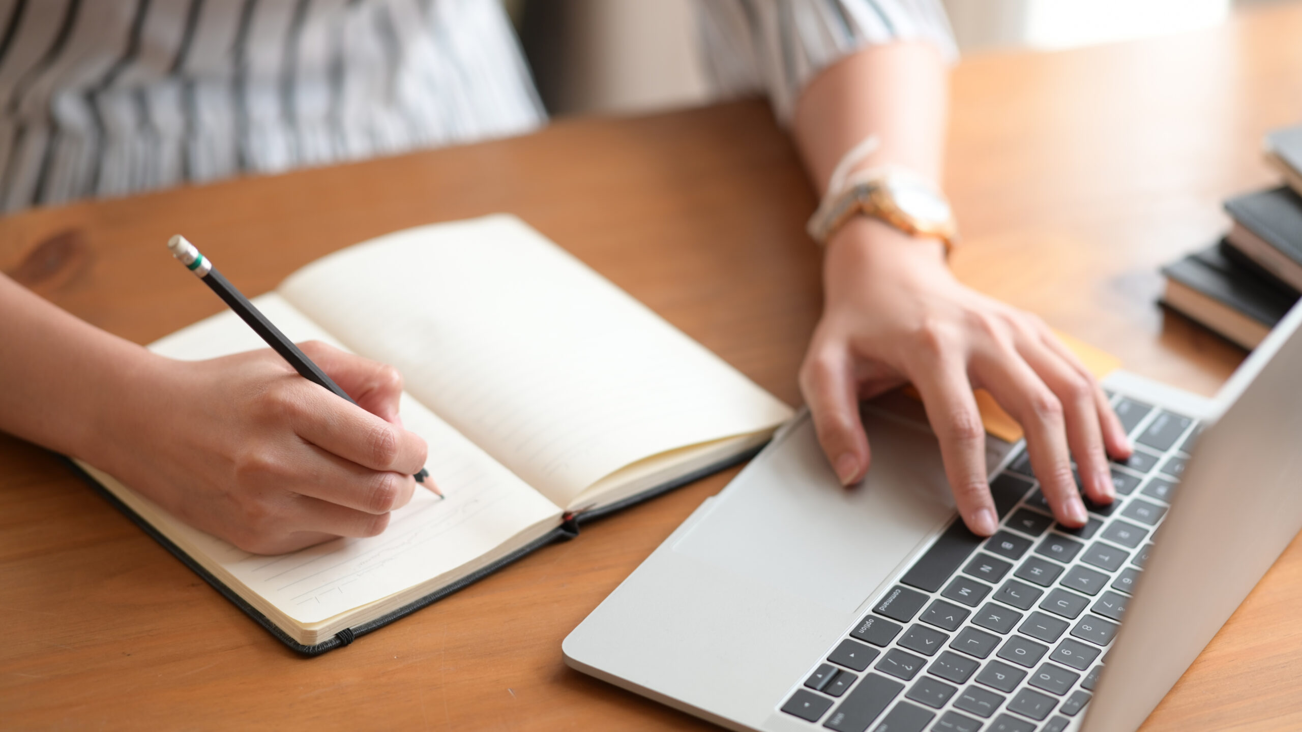 closeup of woman's hand writing in notebook
