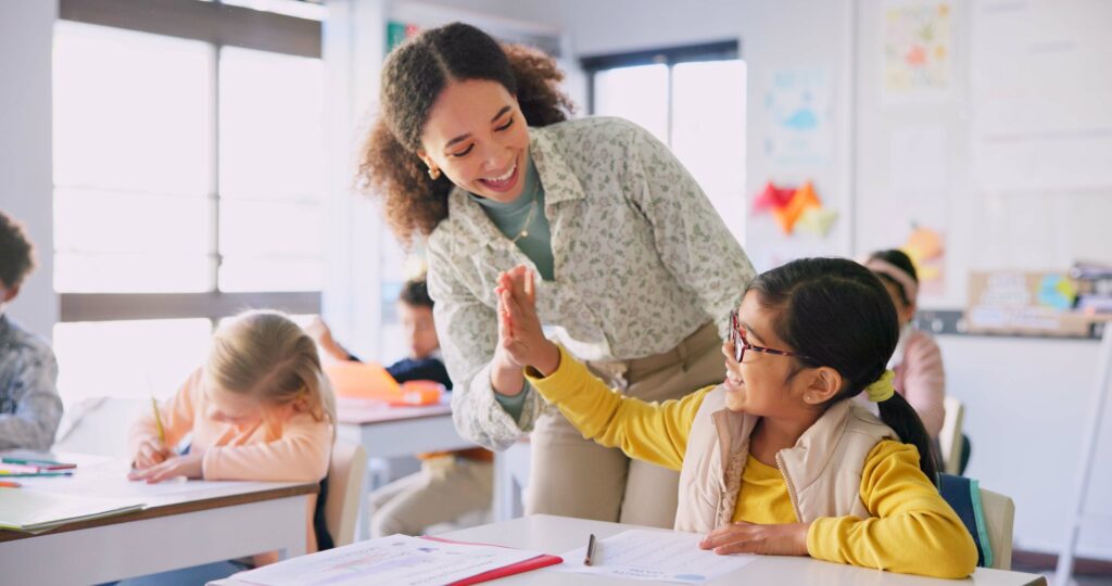 Teacher high fiving student in classroom