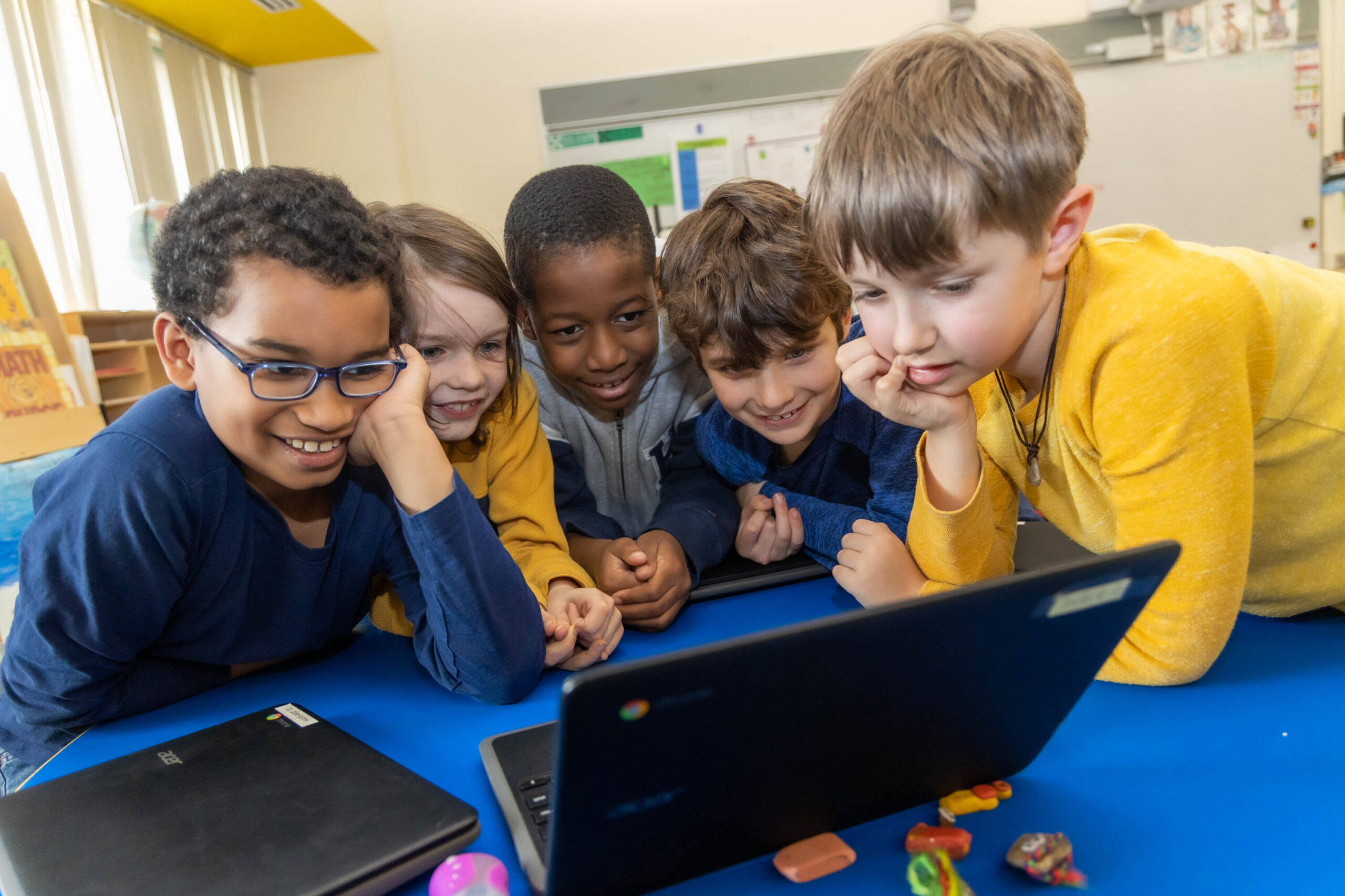 Cambridge School District students|teacher helping student with writing task|Cambridge Public Schools logo