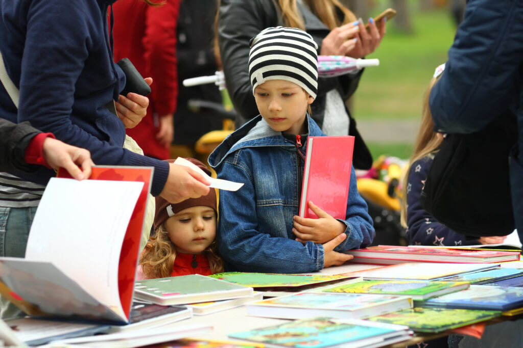 young boy and girl browsing books at book fair table