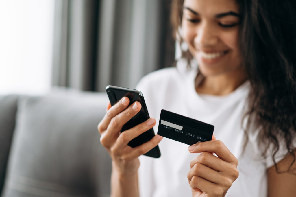 Close-up of woman paying on phone with credit card