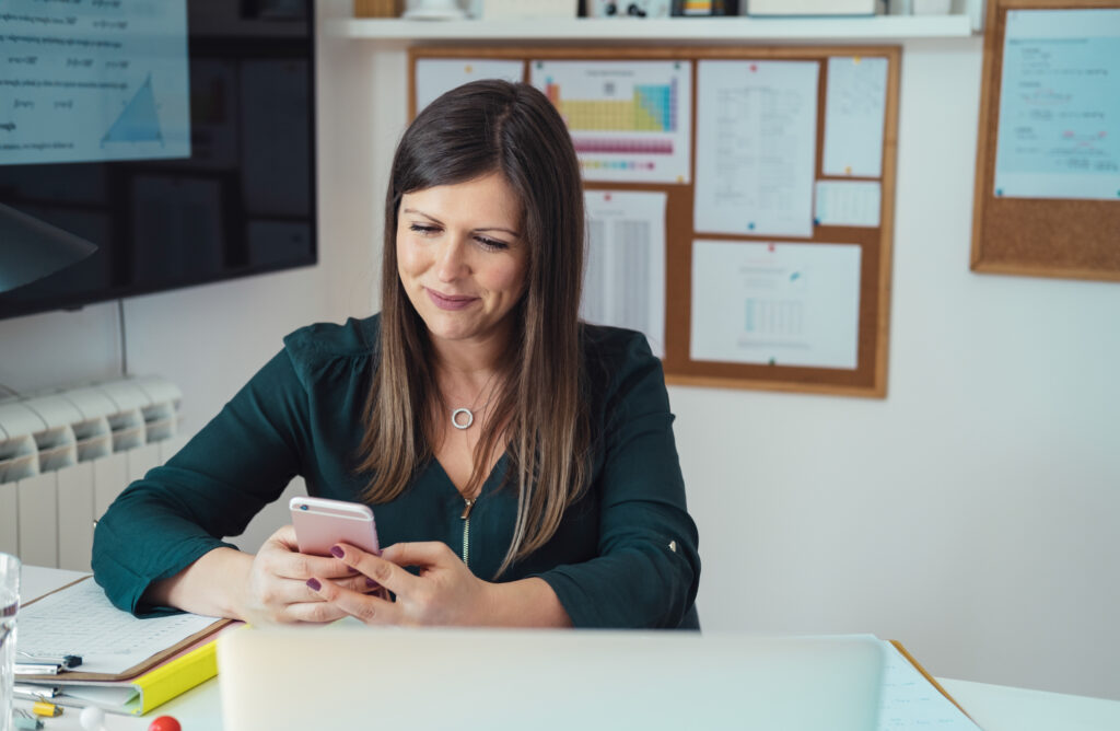 smiling teacher looking at phone