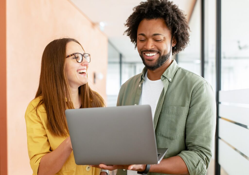 two colleagues having friendly discussion over laptop