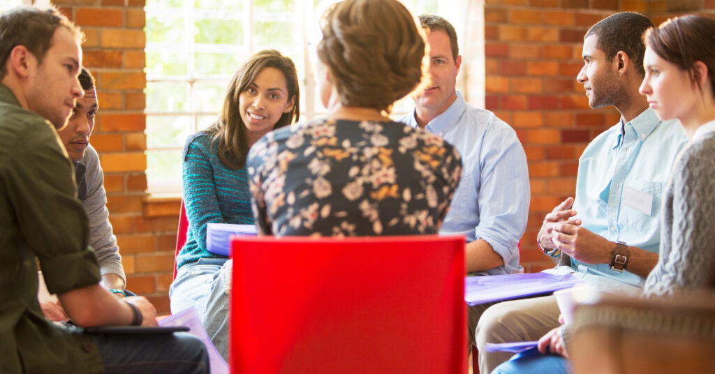 Diverse group of adults sitting around a table and having a conversation